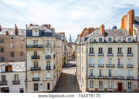 Street view on the beautiful residential buildings andchurch tower in Nantes city during the sunny day in France