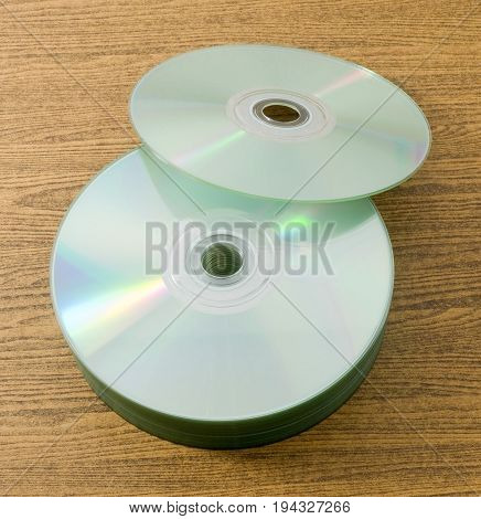 Stack of CD or DVD Compact Disc on A Wooden Table.