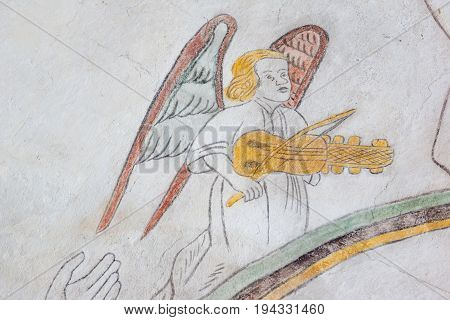 Angel om the rainbow playing the keyed medieval gothic fresco in Vinderslev church Denmark June 22 2017