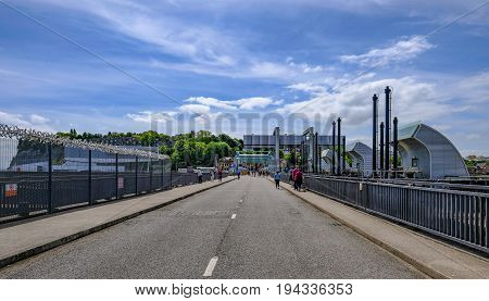 Cardiff Bay Wales - May 21 2017: Road crossing over the barage at Cardiff Bay. Shows pedestrians walking over to the other side of the dam.
