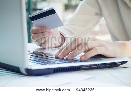 Woman's Hands Holding A Credit Card And Using Smart Phone For Online Shopping.vintage Tone