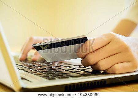 Woman's Hands Holding A Credit Card And Using Smart Phone For Online Shopping.vintage Tone