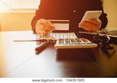 Woman's Hands Holding A Credit Card And Using Smart Phone For Online Shopping.