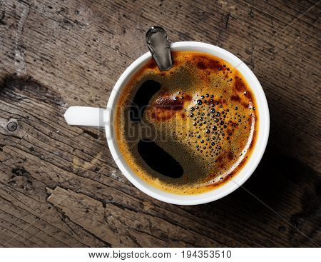 a cup of coffee on a wooden table
