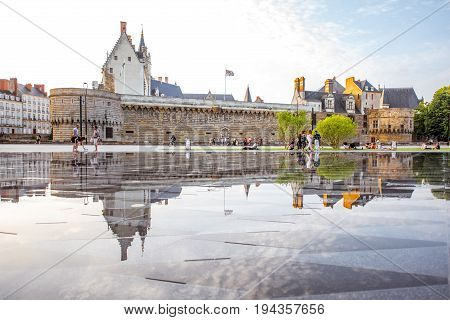 NANTES, FRANCE - May 27, 2017: View on the castle of Dukes of Brittany with water mirror fountain and tourists in Nantes city in France
