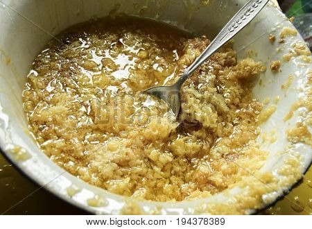 Honey was extracted from honeycombs. Honey and wax are in a bowl.
