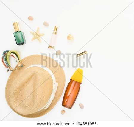 Summer background. Straw hat boho bracelet sun protection spray and cosmetics. Flat lay top view.