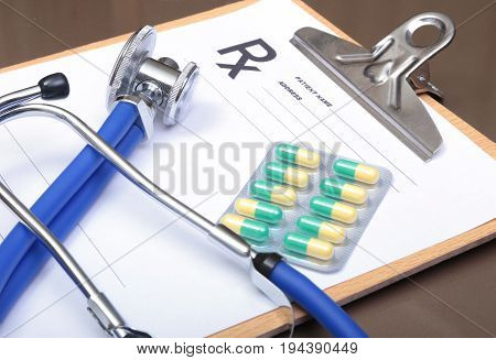 RX prescription, Red heart, asorted pils and a stethoscope on white background.