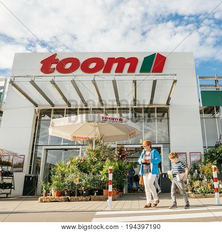 FRANKFURT GERMANY - JUN 30 2017: Mother and child walking to the entrance of TOOM the German DIY-store chain offering home improvement and do-it-yourself goods - customers buying goods selecting the best tools