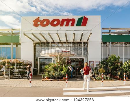 FRANKFURT GERMANY - JUN 30 2017: Woman walking to the entrance of TOOM Baumarkt the German DIY-store chain offering home improvement and do-it-yourself goods - customers buying goods selecting the best tools