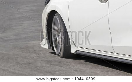 white car has stress of tire in curve street