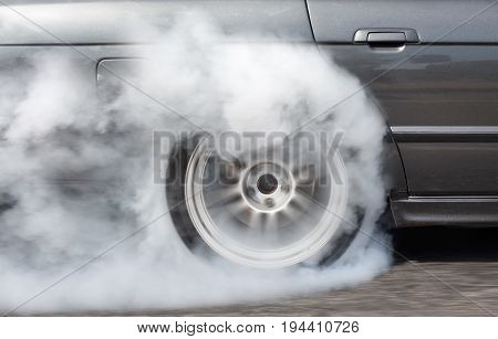 Drag racing car burning tire in preparetion for the race .