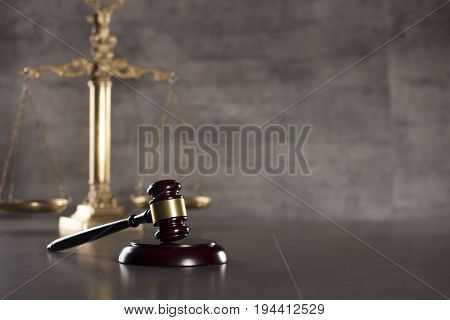 Lawyer office. Gavel, golden scale of justice. Gray stone background. Place for text.