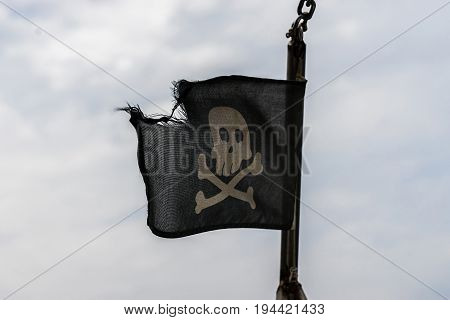 A Jolly Roger ragged flag in the wind