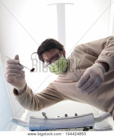 Medical dentist while examining the patient with medical instruments for oral cleansing