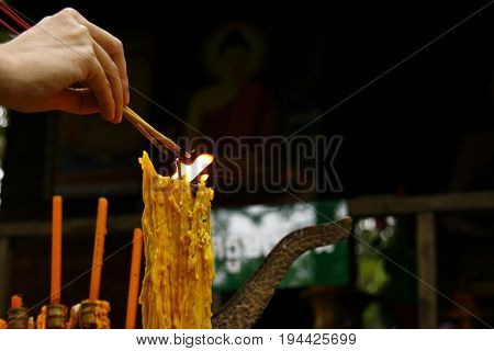 A lighted candle and lit incense with candles frame on the altar of Buddha at temple. a cultural offering for temple prayers.