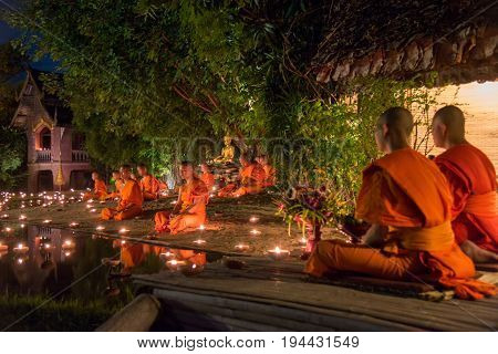CHIANG MAI THAILAND - JULY 08 2017 :Unidentified monks in ritual around Buddha statue among many candlelight at Phan Tao temple Chiang maiThailand in Asanha Puja Day