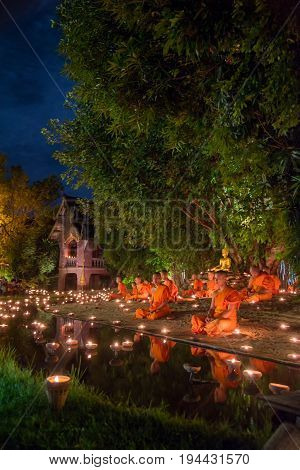 CHIANG MAI THAILAND - JULY 08 2017 :Unidentified monks in ritual around Buddha statue among many candlelight at Phan Tao temple Chiang maiThailand in Asanha Puja Day