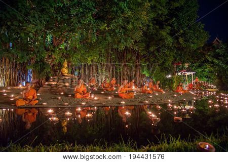 CHIANG MAI THAILAND - JULY 08 2017 :Unidentified monks in ritual around Buddha statue among many candlelight at Phan Tao temple Chiang maiThailand in Asanha Puja Day