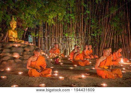 CHIANG MAI THAILAND - JULY 08 2017 :Unidentified monks in ritual around Buddha statue among many candlelight at Phan Tao temple Chiang maiThailand in Asanha Puja Day