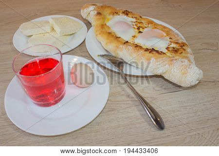 Khachapuri raditional Georgian cheese-filled bread Ajarian style. Adjarian khachapuri with eggs on the table