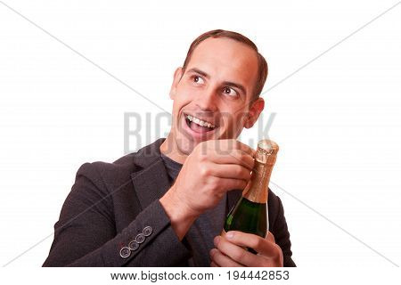 cheerful young man opens a bottle of champagne.
