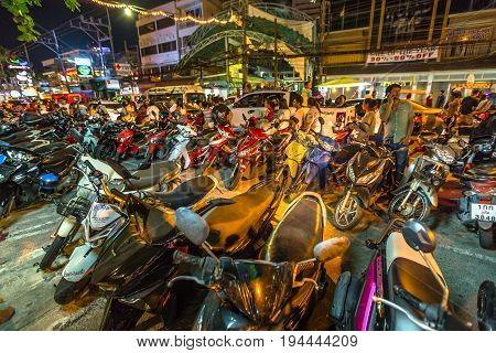 Patong, Phuket, Thailand - January 1, 2016:many scooters parked on sidewalk and street, crowd of tourists, local people with bikes and congested traffic during new year in Patong, famous for nightlife
