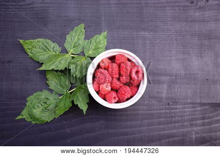 Ripe and tasty raspberries on a wooden background. Raspberries on wooden table .Fresh , vitamins healthy food vegan ingredients.