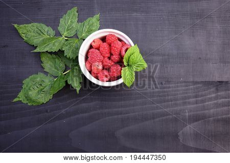 Ripe and tasty raspberries on a wooden background. Raspberries on wooden table .Fresh , vitamins healthy food vegan ingredients.