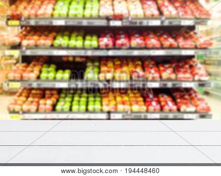 Abstract blur and defocused fruit and vegetables department for background and empty wooden table space platform for present product.