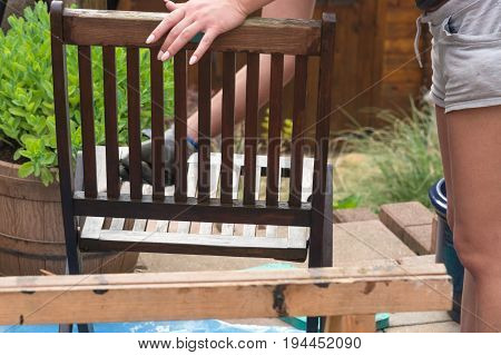 Painting and applying protective varnish on a wooden garden chair