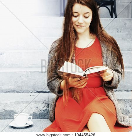 Young beautiful woman reading interesting books in old center of europe city (Knowledge development education success youth concept)
