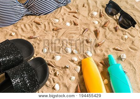 Summer bikini and accessories stylish beach set, Beach bikini summer outfit and sea sand as background, Top View, Concept. Copy space