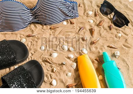 Summer bikini and accessories stylish beach set, Beach bikini summer outfit and sea sand as background, Top View, Concept. Copy space