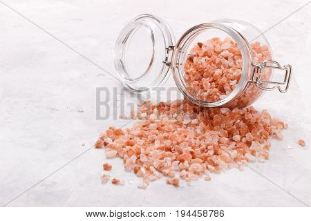 Pink himalayan salt over white stone background, close up top view with space for text