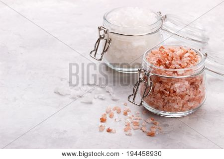 Pink himalayan salt over white stone background, close up top view with space for text