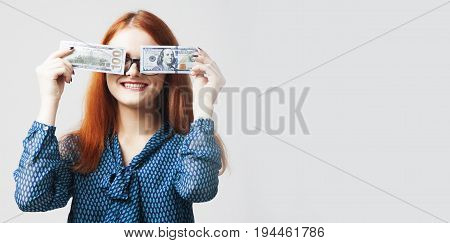 Business Woman covering her mouth with a dollar banknote as symbol of as a symbol of bribery cheating financia and l political manipulation.