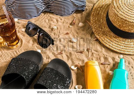 Summer bikini and accessories stylish beach set, Beach bikini summer outfit and sea sand as background, Top View, Concept. Copy space