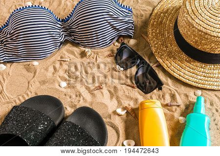 Summer bikini and accessories stylish beach set, Beach bikini summer outfit and sea sand as background, Top View, Concept. Copy space