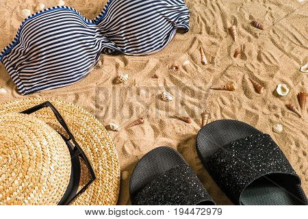 Summer bikini and accessories stylish beach set, Beach bikini summer outfit and sea sand as background, Top View, Concept. Copy space