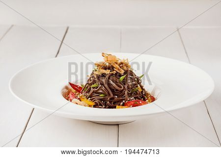 Soba noodles of buckwheat Noodles of buckwheat yellow pepper, tomato and herbs. Pan-Asian cuisine. Place for text. Square photo size. Copy space