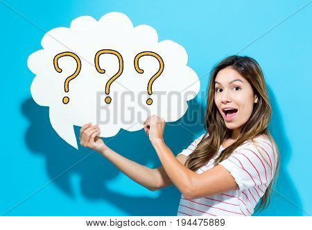 Question Mark text with young woman holding a speech bubble on a blue background