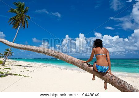 Opálený žena sedí na pláži Klong Prao Palm
