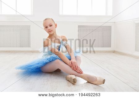 Ballet student exercising in ballet costume, standing on her toes. Young teenager ballerina practicing classical dance pas in studio before performance