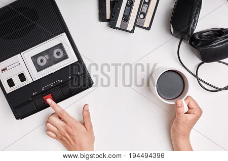 Top View Of Retro Tape Recorder, Cassettes And Headpnones Lying On White Surface. Woman`s Hands Swit