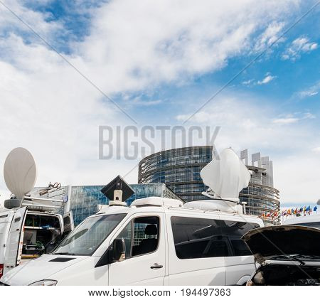 Debate preparation for plenary session: TV Media Television Trucks with multiple Satellite parabolic antennas and fiber optic cables preparing to report live the official European Ceremony