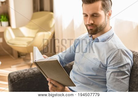 Young male business traveler hotel accomodation reading book