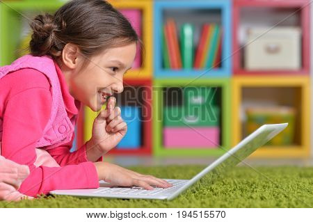 Portrait of cute little girl using modern laptop