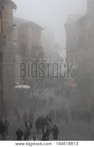 PERUGIA, ITALY. October 26, 2013: The ancient city of Perugia (Tuscany, Italy) with the mist of the morning. Atmosphere and colors that evoke an ancient history. Numerous people walking.
