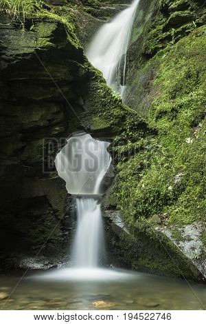 Beautiful Flowing Waterfall With Magical Fairytale Feel In Lush Green Forest Location